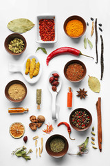 Flat lay of assorted herbs and spices on white background