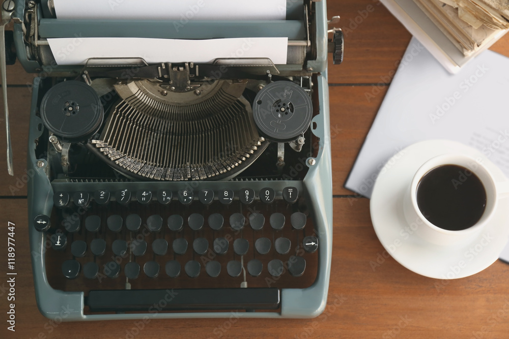 Wall mural Old typewriter and cup of coffee on the table