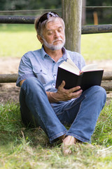 Fototapeta premium Mann liest Buch in der Natur