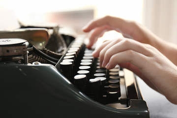 Woman typing on the typewriter, closeup
