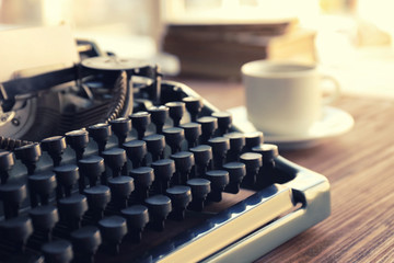 Old typewriter and cup of coffee on the table