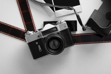 Vintage photo camera with photos on white table