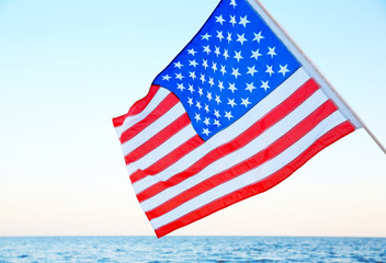 Woman holding American flag on beach