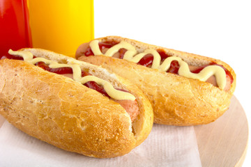 Hotdog with bottle of mustard and ketchup on wooden desk