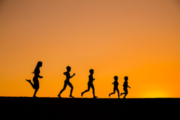 Fototapeta na wymiar silhouette of running kids against sunset