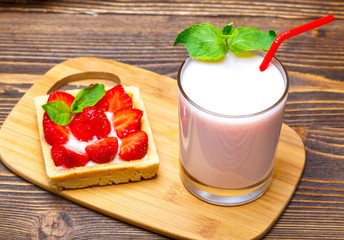 Strawberry ice cream with a cup of yogurt on a wooden background