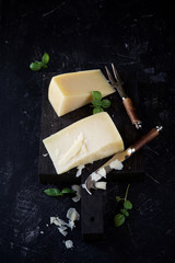 Parmesan cheese with basil on a dark background