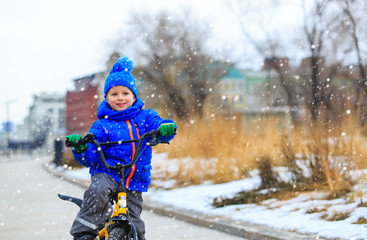 cute little boy riding bike in winter, kids sport