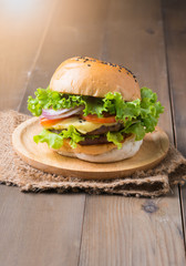 Delicious hamburger on wood palte and wood background