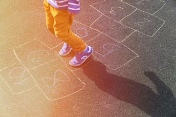 little boy playing hopscotch on playground