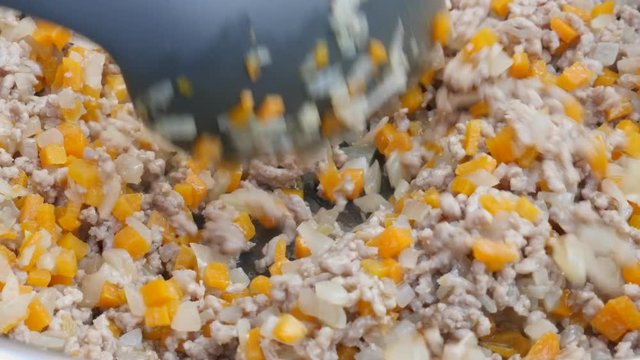 Mixed meat with vegetables frying in the pan close-up 4K 2160p 30fps UHD video - Meat in frying pan mixing with kitchen utensil 4K 3840X2160 UltraHD footage 