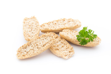 Dry flat bread crisps with herbs on a white background.