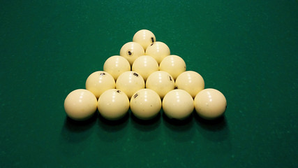 Ivory billiard ball on the green cloth of the table to play