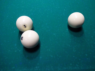 Ivory billiard ball on the green cloth of the table to play