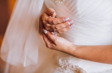 Happy buddies helps bride getting ready for her wedding day in the morning