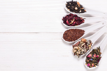 assortment of dry tea on a wooden table,healthy drink