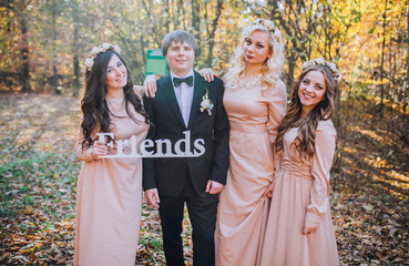 Beautiful bridesmaids with groom in the park