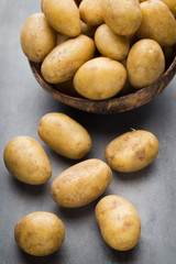 New potato on the bowl, gray background.