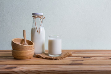 Fresh milk on wooden table over wall background