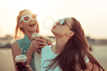 Girls have fun with drinks at the sunset