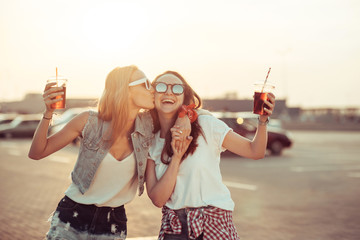 Girls have fun with drinks at the sunset