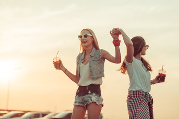 Girls have fun with drinks at the sunset