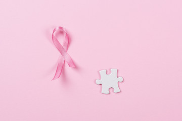 Pink ribbon and puzzle pieces breast cancer.