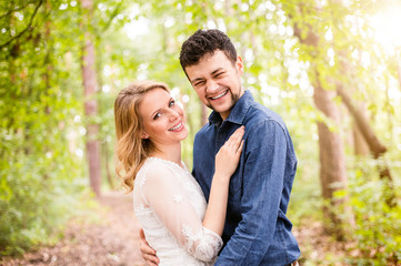 Fototapeta premium Beautiful wedding couple outside in green forest.