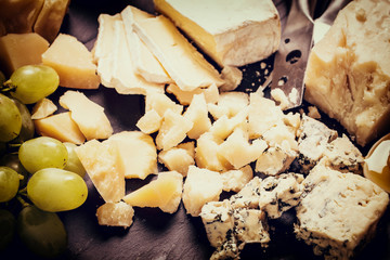 Composition of cheese, berries, bottles and glasses of wine on a wooden table