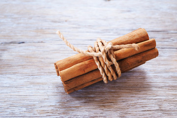 Close up of bundle cinnamon sticks on a wooden background.