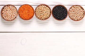 Bowls of various legumes on wooden background,healthy food,vegan food.