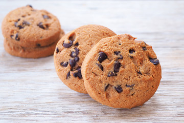 Close up of chocolate chip cookies on a wooden table.