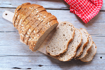 Top view of sliced wholegrain bread on a wooden cutting board.