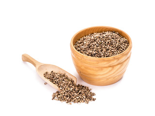 Wooden bowl with hemp seeds and a spoon next to it on white background