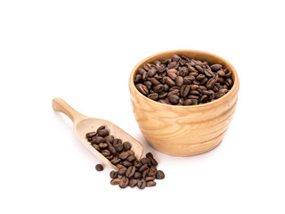 Wooden bowl with roasted coffee beans and a spoon next to it on white background