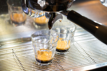 Close-up of espresso pouring from coffee machine. Professional coffee brewing
