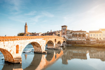 Obraz premium Verona cityscape view on the riverside with historical buildings and towers on the sunset