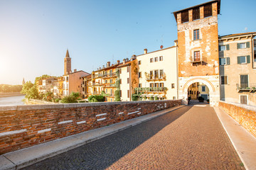 Verona cityscape view on the riverside with historical buildings and watchtower on the sunrise