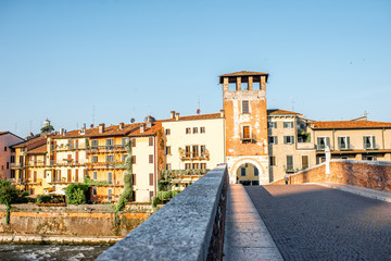 Fototapeta na wymiar Verona cityscape view on the riverside with historical buildings and watchtower on the sunrise