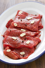 meat with sauce and garlic on white dish