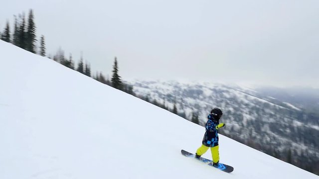Cool snowboarder on the slope at a ski resort in slowmotion. 1920x1080