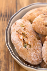 cookies with dry fruits in dish on brown wooden background.