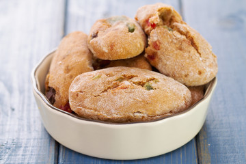 cookies with dry fruits in dish on blue wooden background.