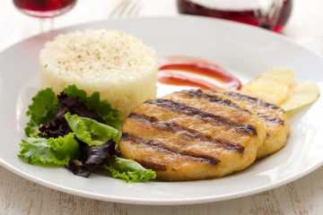 grilled meat with boiled rice and salad on white dish