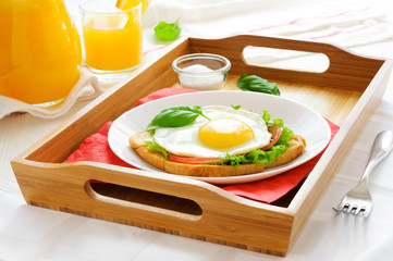 Sandwich with fried egg and orange juice