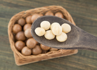 Macadamia nuts in wooden spoon.