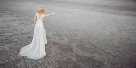 Naklejka premium Beautiful bride outdoors in a desert.