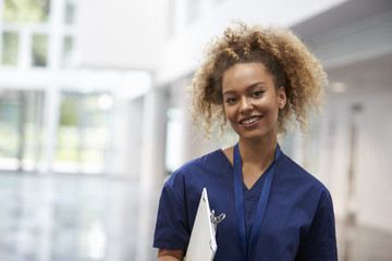 Portrait Of Female Nurse Wearing Scrubs In Hospital - obrazy, fototapety, plakaty