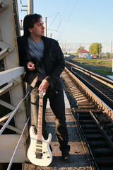 man with a guitar on a railroad