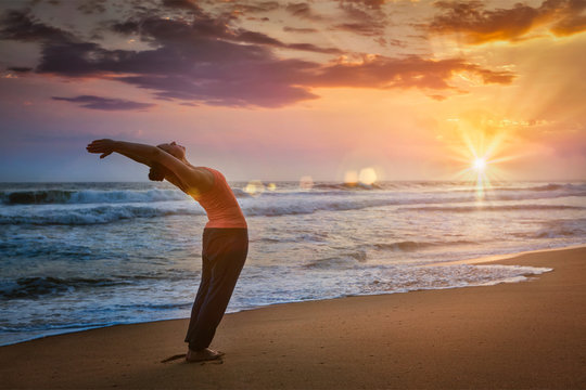 Young sporty fit man doing yoga Sun salutation Surya Namaskar